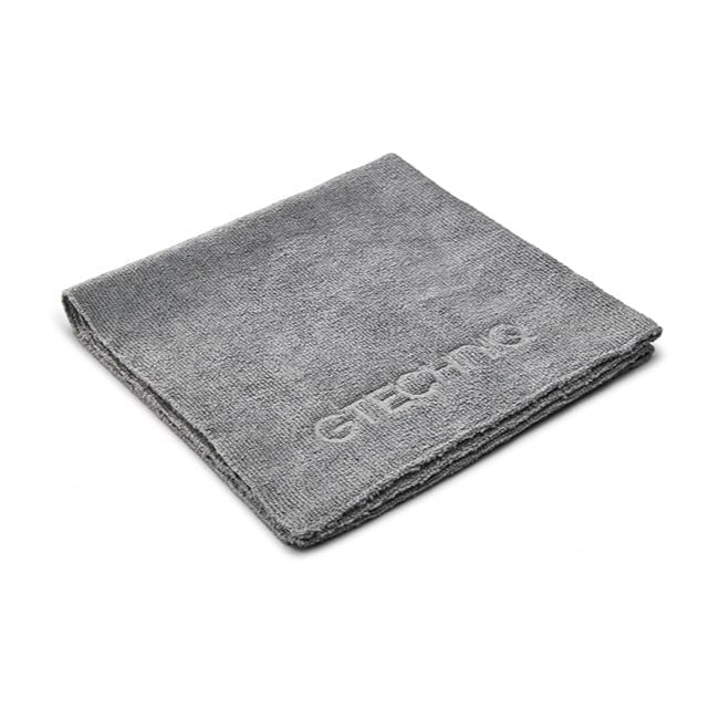 A gray microfiber buff cloth with the GTechniq brand logo on it.